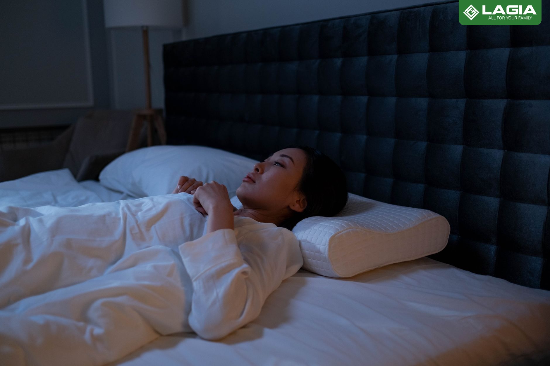 Người phụ nữ nằm ngửa trên giường, tư thế ngủ giúp cột sống thẳng và thư giãn